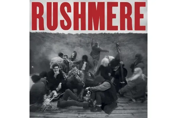 غلاف ألبوم "Rushmere" لفرقة مومفورد وأبناؤه، يظهر مجموعة من الأشخاص في لحظة عفوية، تعكس روح الموسيقى الشعبية والتراث.