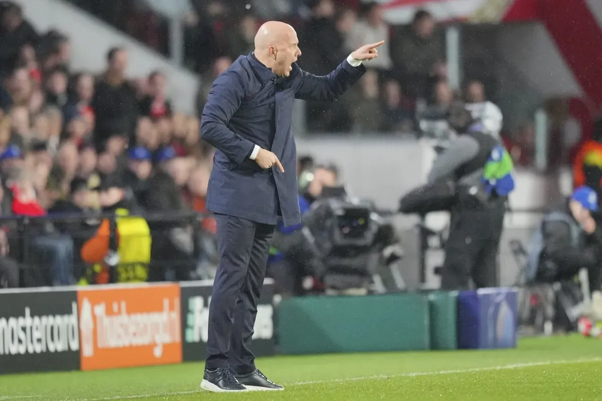 مدرب ليفربول آرني سلوت يشير بيديه خلال مباراة في دوري أبطال أوروبا، محاط بجماهير متحمسة، حيث يسعى لتعزيز أداء الفريق.