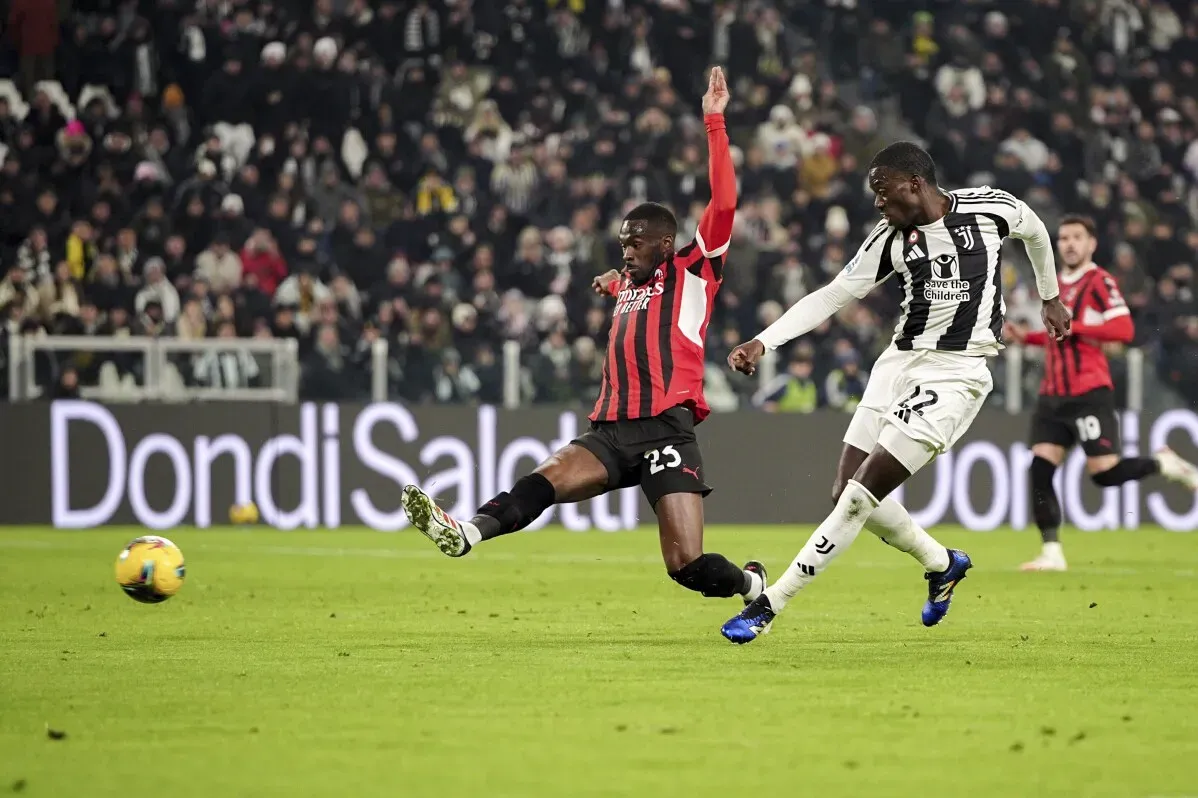 لاعب يوفنتوس تيم ويا يسجل هدفًا ضد ميلان بينما يسعى المدافع لفريق ميلان لإيقافه، في مباراة حماسية بالدوري الإيطالي.