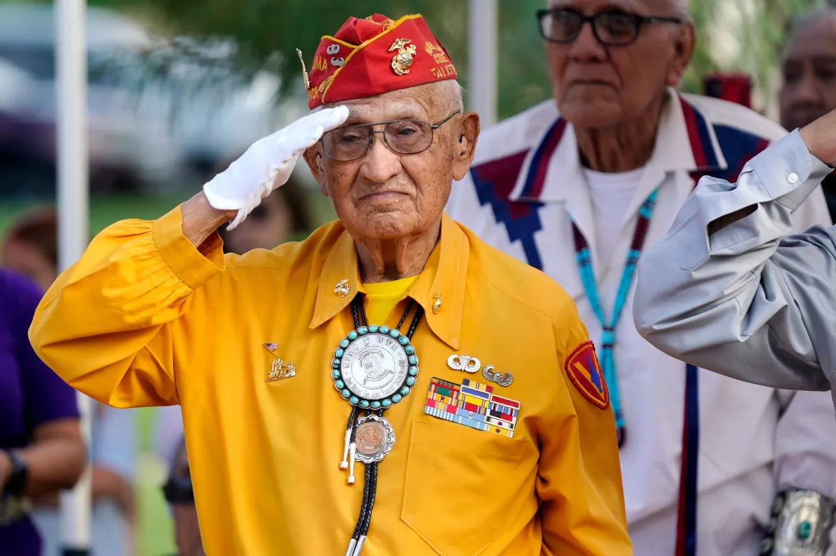 رجل مسن من قبيلة Navajo يحيي ذكرى المتحدثين بالشيفرة في الحرب العالمية الثانية مرتدياً زيًا عسكريًا وشارة شرف في فينيكس.