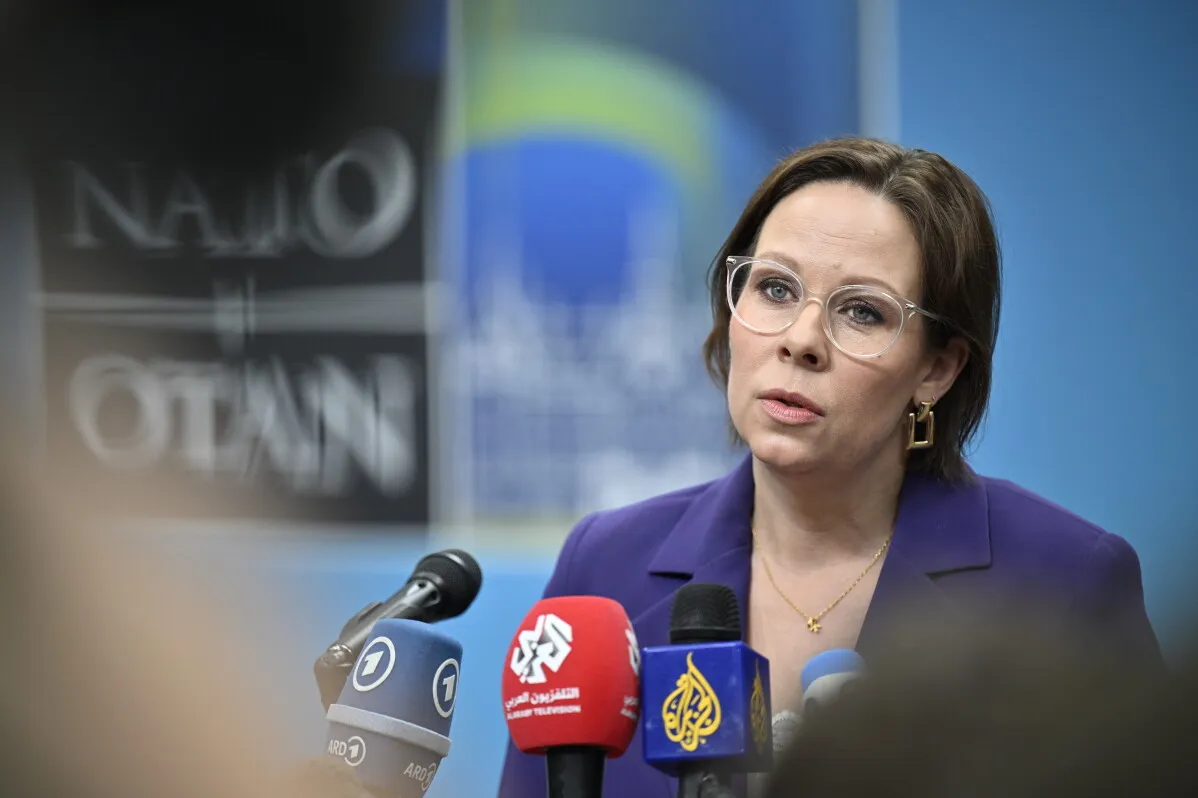 وزيرة الخارجية السويدية Maria Malmer Stenergard تتحدث للصحفيين خلال اجتماع لحلف الناتو في هيلسينغبورغ، مع وجود شعارات الحلف خلفها.