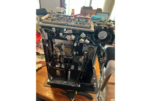 آلة مشبوهة تستخدم في تلاعب ألعاب البوكر، تُظهر الأسلاك والمكونات الداخلية، في سياق تحقيقات مراهنات رياضية غير قانونية.