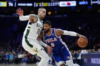 بول جورج لاعب فيلادلفيا 76ers يتجاوز مدافع ميلووكي في مباراة سابقة، وسط أجواء تنافسية. تم إيقافه 25 مباراة بسبب انتهاك برنامج مكافحة المخدرات.