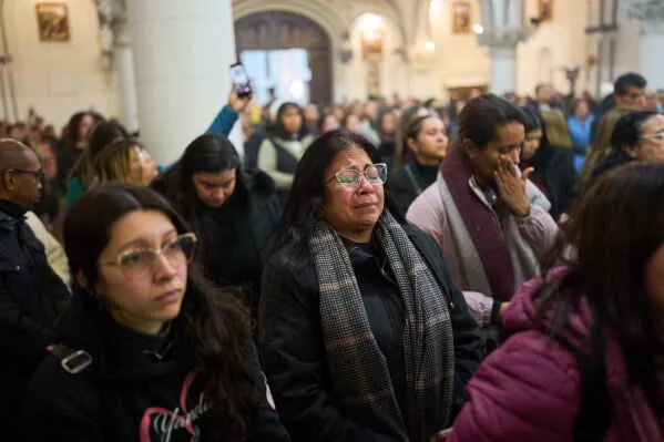 نساء ورجال في كنيسة، بعضهم يبكي، يعبرون عن الحزن بعد الزلزال المدمر في فنزويلا، حيث فقد الكثيرون أحبائهم.