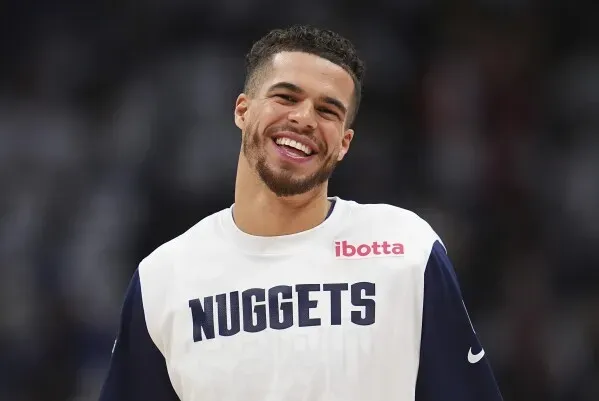 مايكل بورتر جونيور، لاعب دنفر ناجتس، مبتسم أثناء فترة الإحماء، مرتديًا قميص الفريق، في سياق صفقة تبادل اللاعبين مع بروكلين نتس.