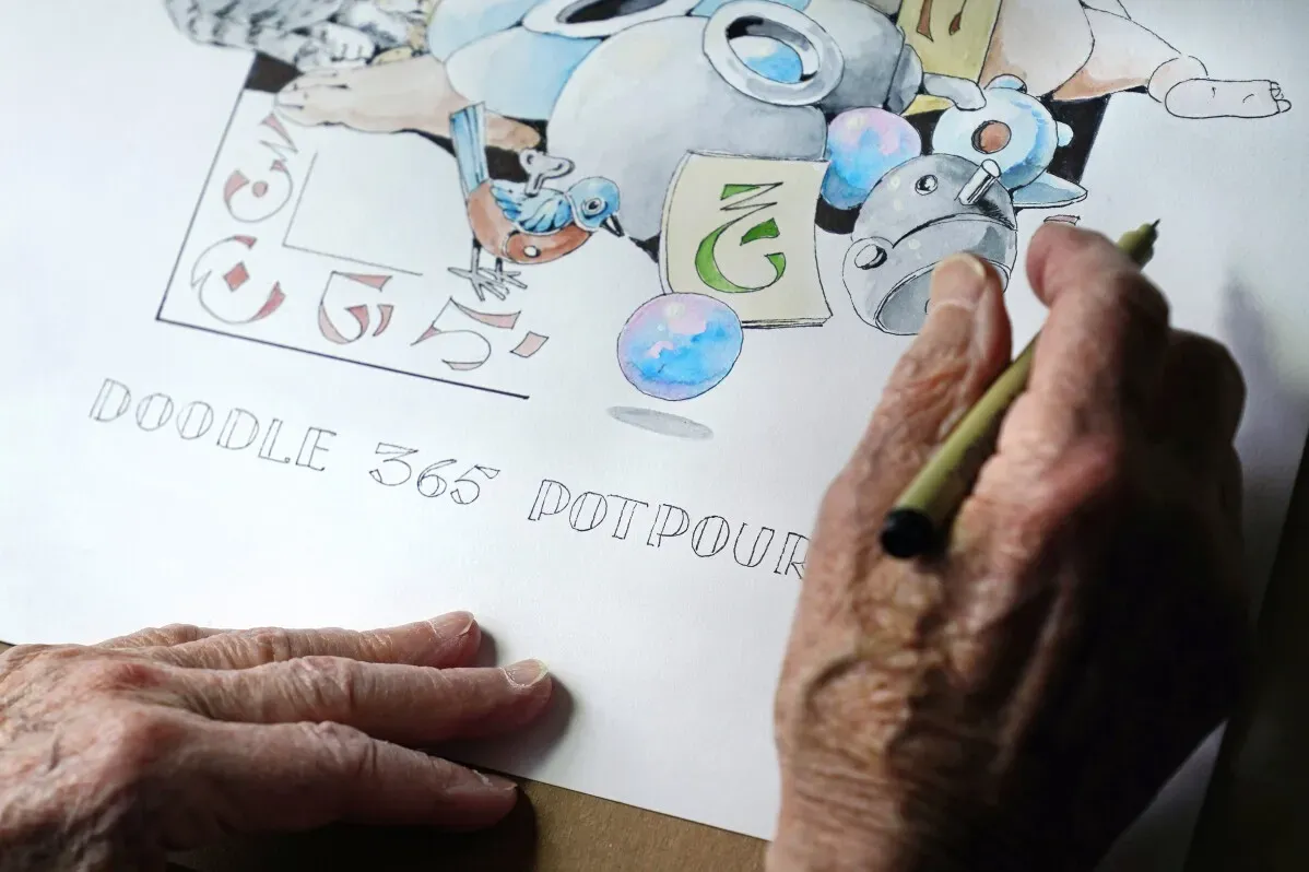 يد تظهر يد فنان مسن وهو يرسم خربشة ملونة بعنوان "Doodle 365 Potpourri"، تتضمن أشكالاً متنوعة وألواناً زاهية.