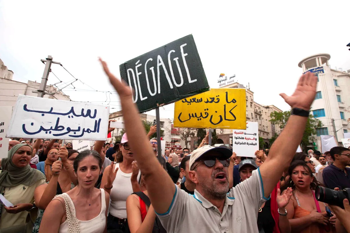 محتجون تونسيون يرفعون لافتات احتجاجية ضد قيس سعيّد وسط تظاهرات غاضبة بسبب أزمة الكهرباء والمياه وموجة الحر الشديدة.