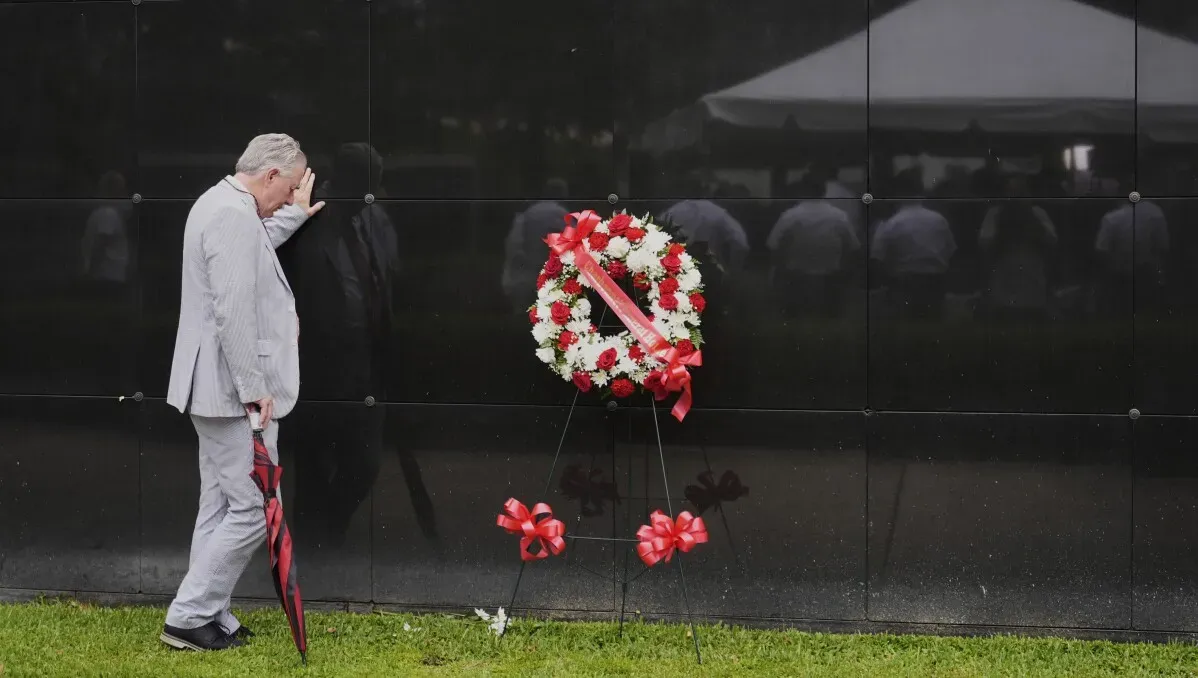 رجل يضع إكليلًا من الزهور أمام نصب تذكاري لضحايا إعصار كاترينا في نيو أورليانز، مستذكرًا التضحيات والأثر المستمر للعاصفة.