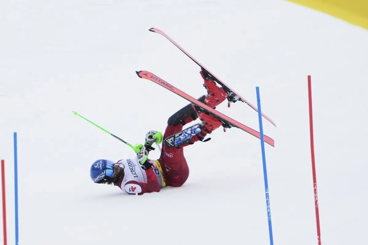 متزلج يتعثر أثناء المنافسة في سباق التعرج، مع التركيز على حركة skis والأعلام الملونة في الخلفية.