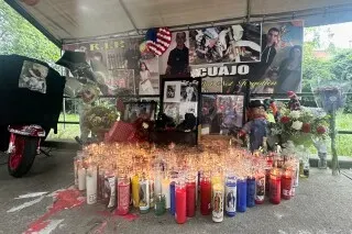 مزار تذكاري لإريك دوبري، يتضمن صورًا وشموعًا ملونة وزهورًا، في ذكرى وفاته بعد حادثة مع ضابط شرطة في نيويورك.