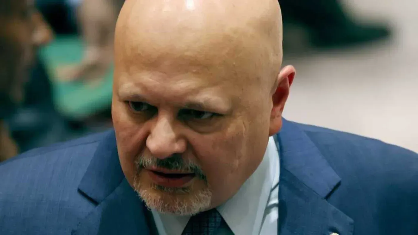 تظهر الصورة كريم خان، المدعي العام للمحكمة الجنائية الدولية، في مناسبة رسمية، مع تعبير جاد يعكس التوتر المحيط بالتحقيقات الجارية في مزاعم سوء السلوك الجنسي.