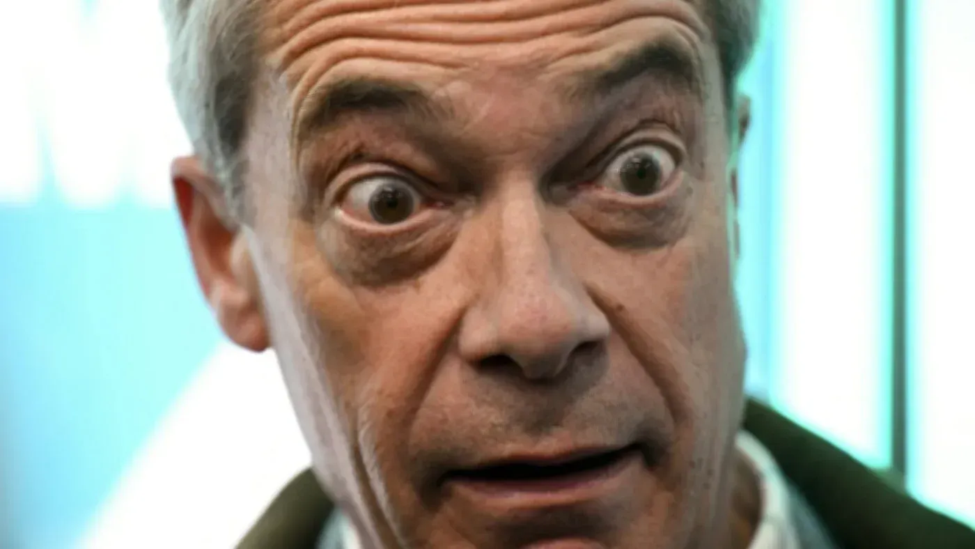 نايجل فاراج يظهر بتعبير مفاجئ أثناء إلقاء خطاب حول تأثير الإسلاميين في بريطانيا، مشيرًا إلى قضايا سياسية وتعليمية.