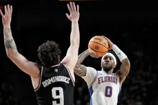 لاعب من فريق فلوريدا يسدد كرة سلة بينما يحاول لاعب من تكساس إيه آند إم الدفاع عنه، في مباراة تنافسية ضمن مؤتمر جنوب شرق الولايات المتحدة.