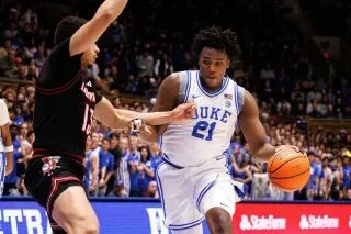 كاميرون بوزر، لاعب فريق ديوك، يتقدم بالكرة أثناء مباراة ضد لويزفيل، مع التركيز على الأداء القوي للفريق في الهجوم والدفاع.