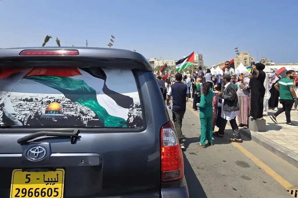 سيارة تحمل علم فلسطين في مقدمة حشد من المتظاهرين في طرابلس، حيث يحتفل المشاركون في قافلة "صمود" بتضامنهم مع غزة.