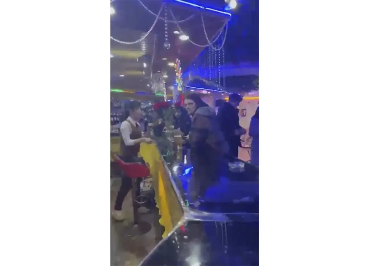 مشهد داخلي لمطعم في كوريا الشمالية، حيث يظهر السياح الأجانب يتفاعلون مع الموظفين، مما يعكس استئناف السياحة الدولية.