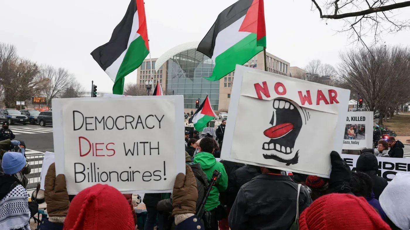 محتجون يحملون لافتات تدعو إلى حقوق الفلسطينيين، مع أعلام فلسطينية في الخلفية، خلال مظاهرة ضد الحرب في واشنطن.