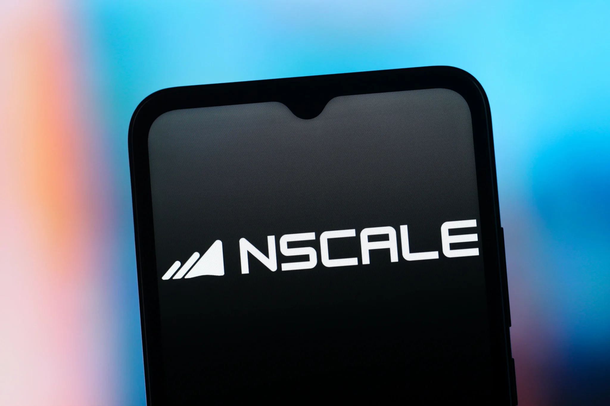 شعار شركة Nscale البريطانية المتخصصة في الحوسبة السحابية والذكاء الاصطناعي على شاشة هاتف ذكي، مع خلفية ملونة تعكس استعداد الشركة للطرح العام الأولي في بورصة نيويورك.