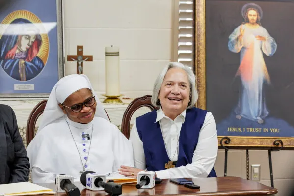 راهبتان تجلسان بابتسامة في مؤتمر صحفي داخل كنيسة Our Lady of Sorrows في مكالين، تكساس، لمناقشة قضية ترحيل الراهبة أوغبواجا.