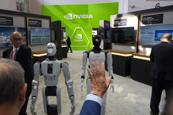 عرض روبوتين بشريين أمام جناح شركة Nvidia في معرض تقني، مع تفاعل الزوار وسط منافسة شركات الذكاء الاصطناعي العالمية والصينية.