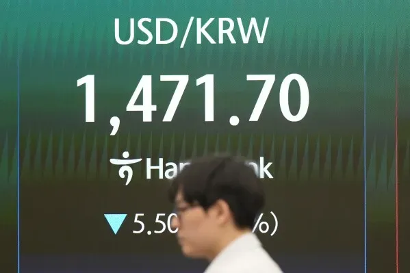 سعر صرف الدولار الأمريكي مقابل الوون الكوري الجنوبي يبلغ 1,471.70، مع انخفاض قدره 5.50 (-0.37%)، في خلفية شخص يمشي.