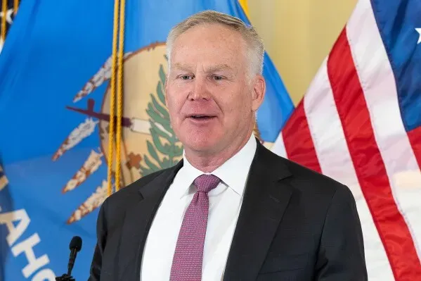 آلان أرمسترونغ، المدير التنفيذي للطاقة، يتحدث في مؤتمر صحفي بعد تعيينه في مجلس الشيوخ الأمريكي، مع العلم الوطني لأوكلاهوما في الخلفية.