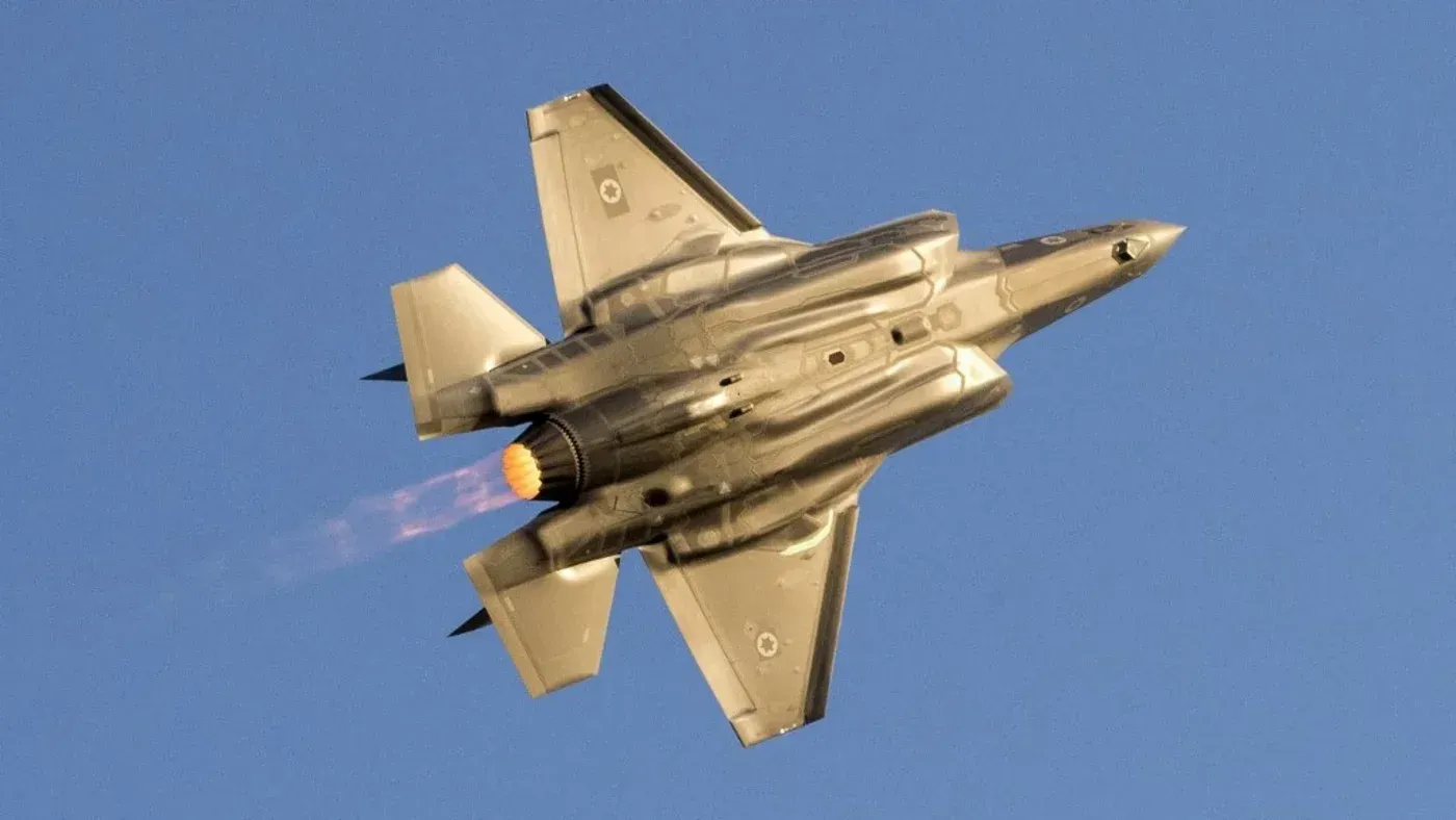 طائرة F-35 مقاتلة تطير في السماء، مع انبعاث لهب من محركاتها، مما يعكس الاستخدام العسكري المتزايد لها في النزاعات.
