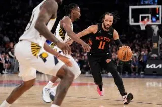 لاعب نيويورك نيكس يت dribble الكرة بينما يحاول المنافسون من إنديانا بيسرز الدفاع عنه خلال مباراة مثيرة في الدوري الأمريكي للمحترفين.
