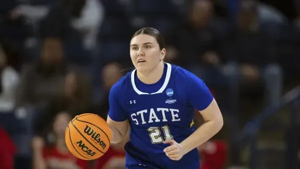 لاعبة كرة السلة بيج ماير من ولاية ساوث داكوتا الجنوبية تحمل الكرة، مستعدة للعب في بطولة NCAA.