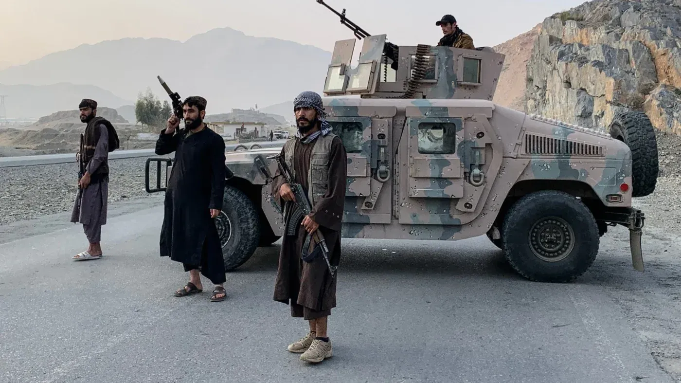 مقاتلو طالبان يقفون مسلحين بالقرب من مركبة عسكرية في منطقة جبلية، وسط تصاعد التوترات بين باكستان وأفغانستان.