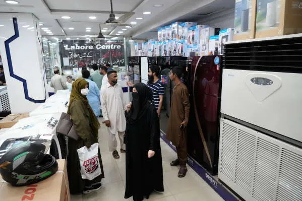 متسوقون في متجر للأجهزة المنزلية في باكستان، حيث تبرز الضغوط الاقتصادية المتزايدة على الأسر وسط ارتفاع تكاليف المعيشة.