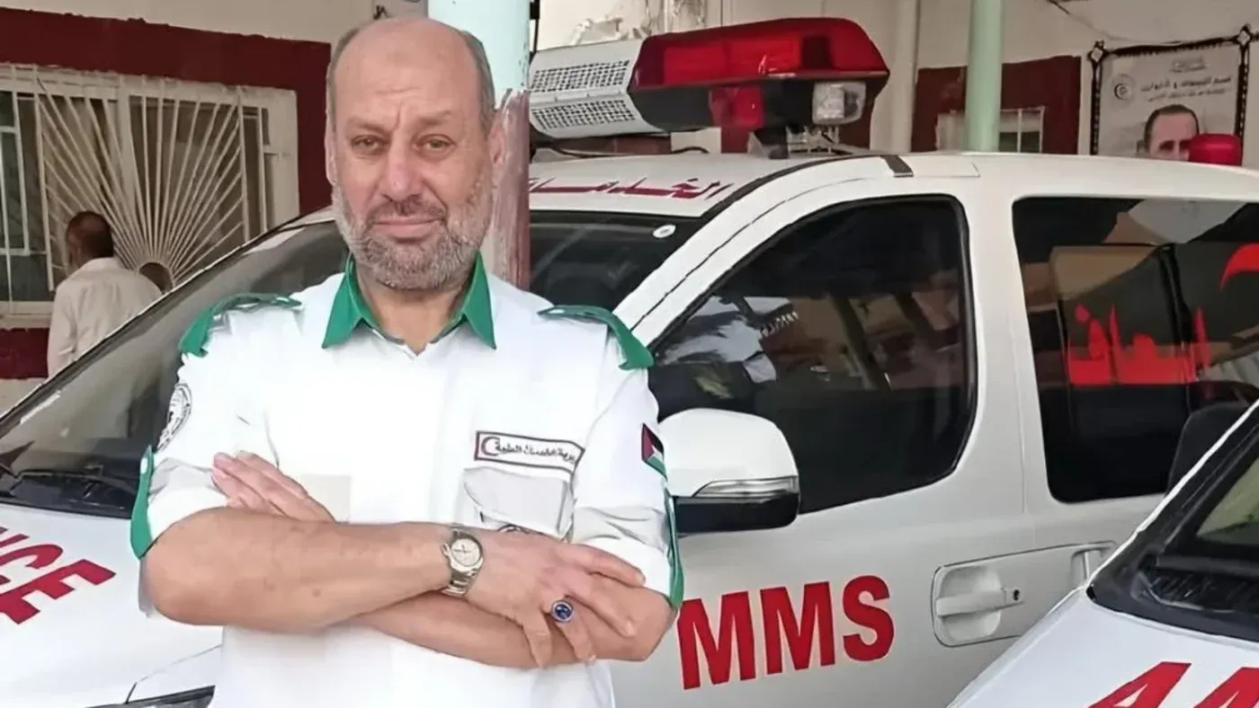 حاتم إسماعيل ريان، مسعف فلسطيني، يقف أمام سيارة إسعاف، حيث توفي في السجون الإسرائيلية بعد اعتقاله في ظروف قاسية.