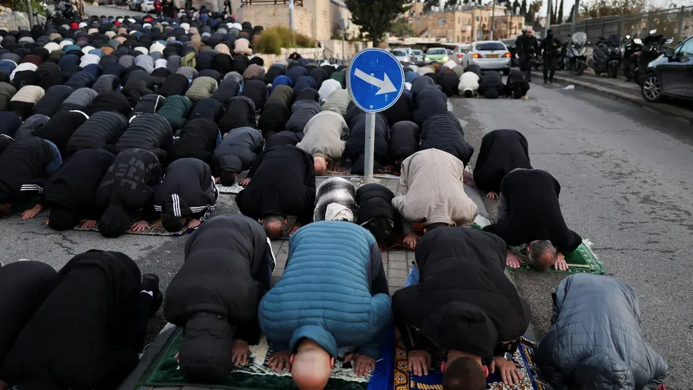 مصلون فلسطينيون يؤدون صلاة عيد الفطر في الشارع خارج البلدة القديمة بالقدس، وسط تواجد مكثف للشرطة الإسرائيلية.