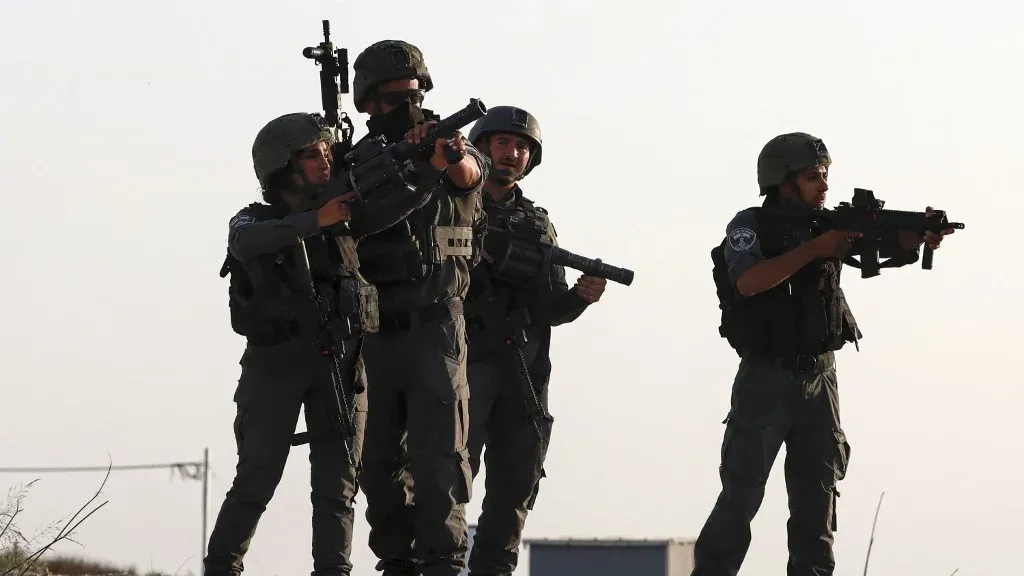 مجموعة من الجنود الإسرائيليين مسلحين في موقع مفتوح، تعبير عن التوتر العسكري في قطاع غزة وسط رفض فلسطيني لنزع سلاح حماس قبل الانسحاب الإسرائيلي.