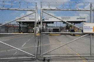 بوابة محاطة بسياج لميناء بنما، مع لافتة تشير إلى ملكية شركة PPC، تعكس التطورات الأخيرة في استيلاء الحكومة على الموانئ.