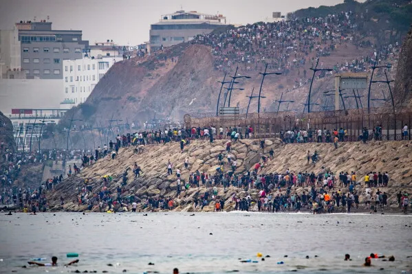 حشود كبيرة من المهاجرين يعبرون الحدود البحرية بين المغرب ومدينة سبتة الإسبانية، في ظل أزمة الهجرة وتأثيرها على استضافة كأس العالم 2030.