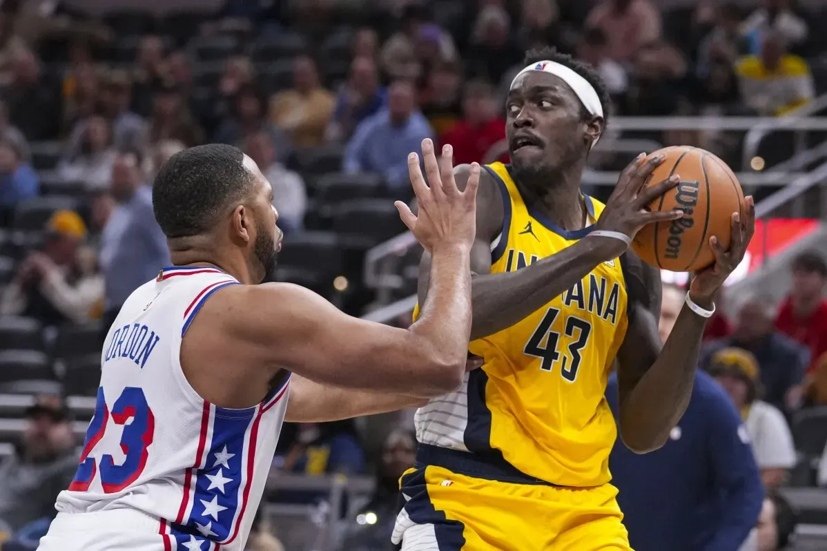 باسكال سياكام لاعب إنديانا بيسرز يتلقى ضغطًا من لاعب فيلادلفيا 76ers، مع التركيز على المنافسة في مباراة الدوري.