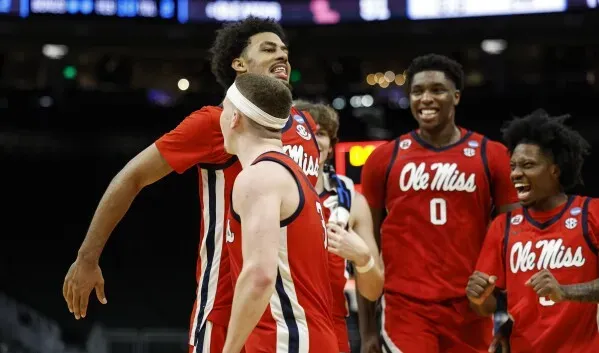 فريق أولي ميسيسيبي يحتفل بفوزهم على ولاية أيوا في بطولة NCAA، مع تعبيرات الفرح والنجاح بين اللاعبين.