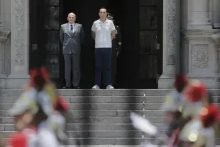 رجلان يقفان على الدرجات أمام مبنى حكومي في ليما، بيرو، وسط أجواء من عدم الاستقرار السياسي بعد عزل الرئيس المؤقت خوسيه جيري.