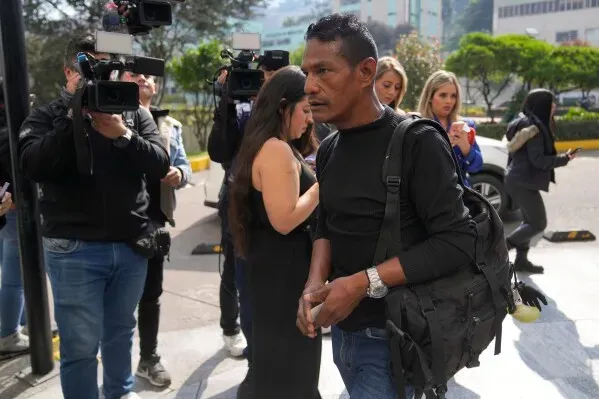 رجل يحمل حقيبة ظهر يتوسط مجموعة من الصحفيين أثناء تغطيته لحادث تحطم الطائرة العسكرية في كولومبيا، حيث قُتل 67 جندياً.