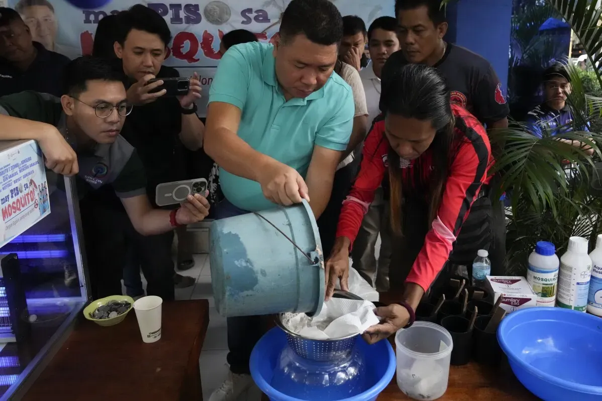 سكان قرية أديشن هيلز في ماندالويونغ يقومون بتسليم يرقات بعوض في حملة لمكافحة حمى الضنك، وسط اهتمام إعلامي واضح.