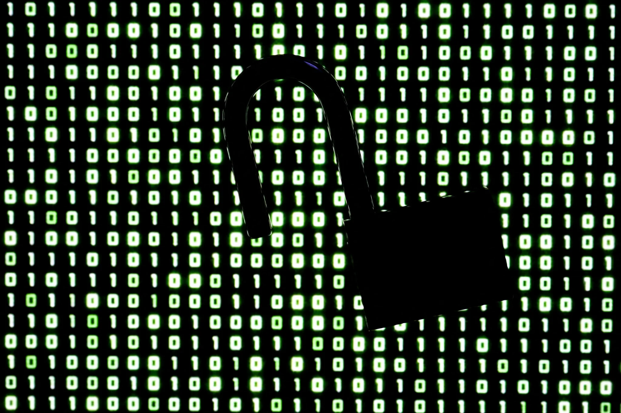 قفل مفتوح أمام خلفية أرقام ثنائية باللون الأخضر، يرمز إلى ثغرات أمنية في لغة PHP تهدد أنظمة الحماية الإلكترونية.