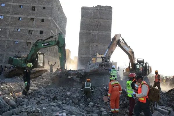 انهيار مبنى في نيروبي أثناء عملية هدم، مع وجود عمال إنقاذ وآليات ثقيلة في الموقع، حيث تم انتشال الضحايا من تحت الأنقاض.
