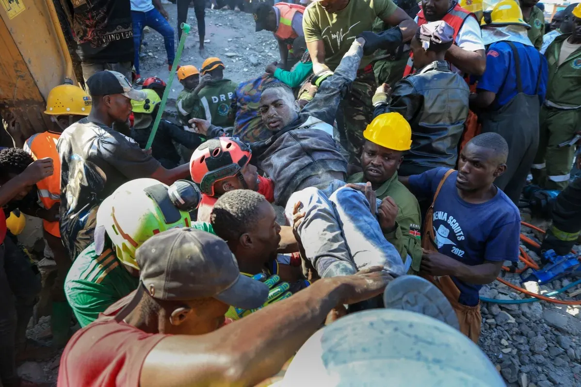 عمال الإنقاذ يحملون شخصًا مصابًا من تحت أنقاض مبنى انهار أثناء عملية هدم في نيروبي، مما أسفر عن مقتل وإصابة عدة أشخاص.