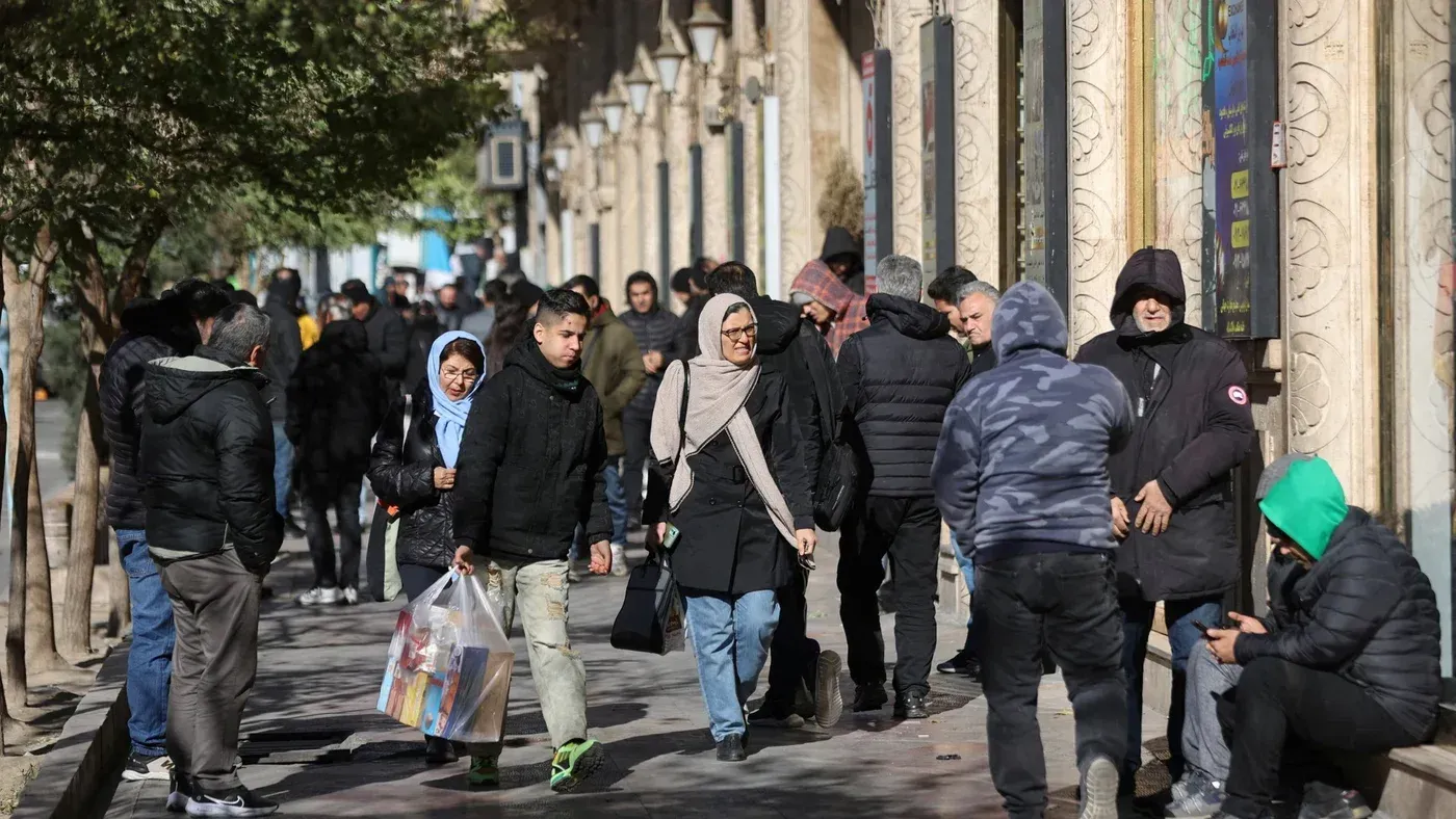 مشهد لشارع مزدحم في طهران، حيث يتجمع الناس في أجواء من التوتر الاقتصادي، مع تراجع قيمة الريال الإيراني.