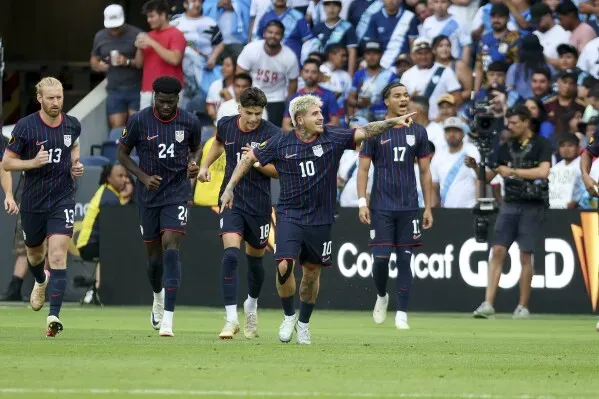 احتفال لاعبي منتخب الولايات المتحدة بعد تسجيل هدف في مباراة كأس الذهبية أمام غواتيمالا، وسط جمهور متنوع في ملعب إنرجايزر بارك.