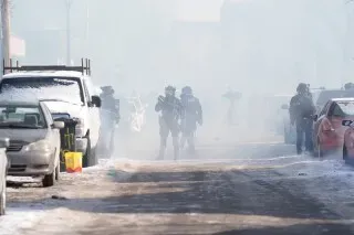 مظاهرة في مينيابوليس وسط ضباب كثيف، حيث يظهر ضباط يرتدون معدات مكافحة الشغب في الشارع، مع وجود سيارات متوقفة في الخلفية.