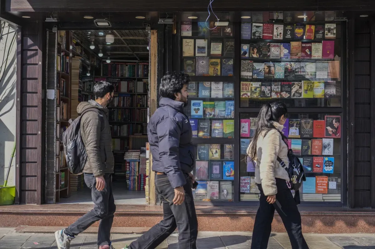 مشاة يمرون أمام واجهة مكتبة في سريناغار، حيث تعرضت المكتبة لمداهمات من الشرطة وصودرت كتب مرتبطة بمنظمة إسلامية محظورة.
