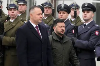 الرئيس الأوكراني زيلينسكي يقف بجانب المسؤول البولندي نافروتسكي، وسط حرس شرف، في سياق توتر تاريخي بين بولندا وأوكرانيا.