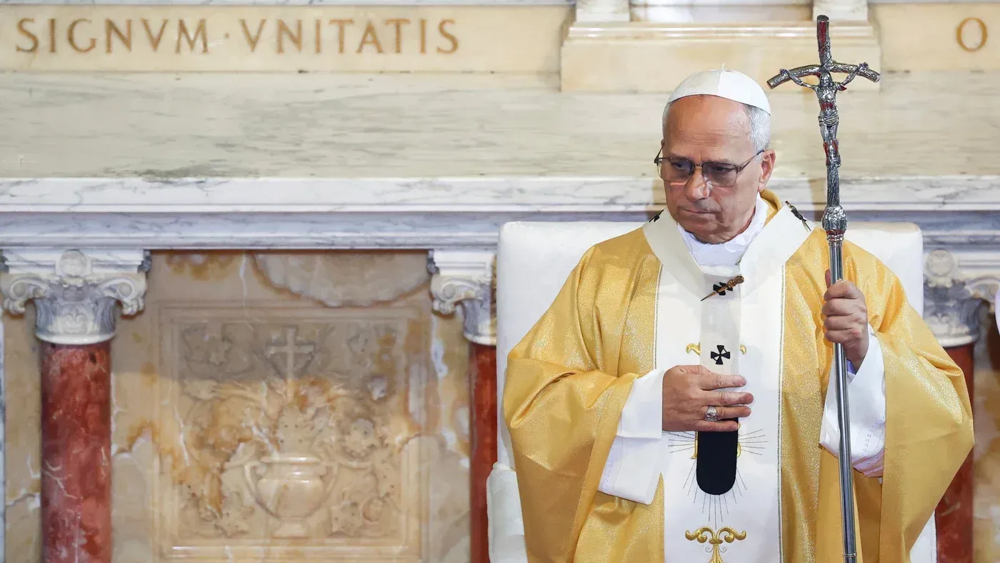 البابا ليون الرابع عشر يرتدي ثوباً كهنوتياً أثناء قداس، ممسكاً بعصا رعاوية، في إطار سياق ديني يتناول قضايا الحرب والسلام.